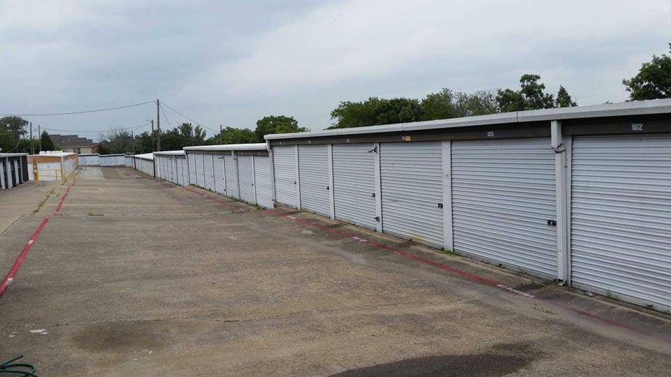 A long row out large outdoor storage units with white doors