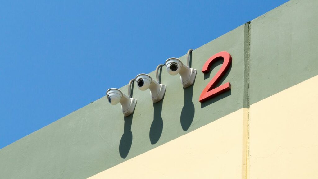 Exterior surveillance cameras on the side of facility building